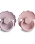Two Frigg Daisy pacifiers in Soft Lilac and Baby Pink on a white background