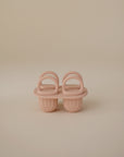 A mushie Toddler Ice Pop Tray in blush pink silicone, shown upright on a beige background—ideal for little ones who enjoy rainbow-shaped popsicles or playful moments with their own ice pop tray.