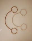 Two mushie Adjustable Silicone Straps (2-Pack), one brown and one beige, are styled on a smooth surface to suggest a minimalist, modern smile—showcasing baby essentials designed with contemporary flair.