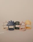 The mushie No-Drop Dino Teether (Tradewinds) is a charming silicone teether shaped like a dinosaur, designed for easy gripping—perfect for soothing babies’ gums and fits comfortably in little hands.