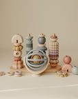 Set of pastel-colored wooden toys and a suction spinner ball toy on a beige background