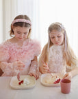 Two girls enjoy dessert with mushie Square Dinnerware Plates, BPA-free and dishwasher safe.