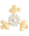The mushie Suction Spinner Toy in Bee color is a baby teether shaped like a white flower with three light yellow bees, made from food-grade silicone for a safe sensory experience.