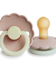 Two FRIGG Daisy Natural Rubber Pacifiers in Blush Night, one lying flat to display the nipple and the other upright showing the handle. Limited Edition 2-pack featuring scalloped edges.