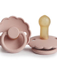 The FRIGG Daisy Natural Rubber Pacifier 2-Pack | Limited Edition features two pink pacifiers—one flat showing the natural rubber nipple, one upright displaying the front ring. Both pacifiers are branded FRIGG at the base.
