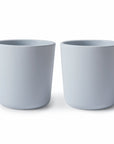 Two plain, light gray ceramic plant pots are side by side on a white background. Both empty pots have a simple, smooth design—a stylish alternative to mushie Dinnerware Cups for those seeking elegance over colorful options.