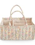 The mushie Diaper Caddy in Pastel Blooms features a rectangular quilted design with handles and multiple interior compartments, displayed against a white background.