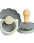 The FRIGG Daisy Natural Rubber Pacifier 2-Pack | Limited Edition by FRIGG features two pacifiers with scalloped edges—one with a gray and cream handle, the other showing the yellow nipple and gray shield—resting on a white surface.