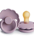 The FRIGG Daisy Natural Rubber Pacifier 2-Pack | Limited Edition by FRIGG features two lavender pacifiers with scalloped edges—one displays the handle and the other stands upright, both offering gentle comfort with natural rubber latex.