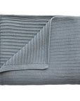 The mushie Knitted Ribbed Baby Blanket is shown neatly folded in light gray, displaying its breathable ribbed knit texture with both front and back sides visible.