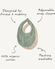The mushie Muslin Bib set includes two teething bibs, one green and one beige, designed for softness and mobility with an adjustable snap closure. Made from 100% organic cotton muslin, they're machine washable for easy care.