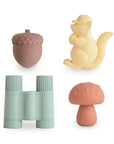 The mushie Nature Mold Free Bath Play Set includes four food-grade silicone bath toys—a brown acorn, yellow squirrel, blue binoculars, and orange mushroom—for safe, nature-inspired play.