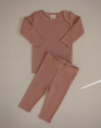 The mushie Two Piece Set, featuring a matching long sleeve shirt and pants in dusty pink, made from breathable fabric for babies, is displayed flat on a light beige background.