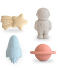 The mushie Space Mold Free Bath Play Set includes four pastel silicone toys—a yellow star, gray astronaut, blue rocket, and pink ringed planet—arranged on a white background for safe, playful, mold-free bath time fun.