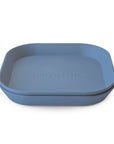 Two stacked, square, blue silicone Square Dinnerware Plates by mushie with rounded edges and "mushie" embossed in the center—an ideal BPA-free alternative to plastic dinnerware.