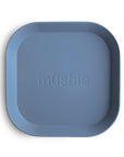 The mushie Square Dinnerware Plate is a blue, BPA-free silicone plate with rounded corners and "mushie" embossed in the center—ideal for babies.