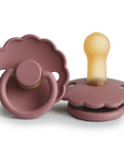 Two FRIGG Daisy Natural Rubber Pacifiers in Woodchuck are shown: one flat to show the front, the other upright showing the latex nipple. The FRIGG brand name is visible at the base. Limited Edition 2-Pack.