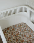 White crib with mushie Extra Soft Muslin Crib Sheet in a bright, neutral nursery.