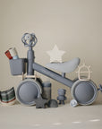 A mushie Mini Toddler Bike surrounded by baby toys and accessories.