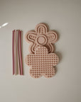 Two mushie Silicone Sensory Toys next to eight pastel straws.