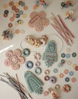 Mushie Silicone Sensory Toy and stacking rings enhance fine motor play on a light surface.