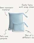 Two light blue mushie Water Resistant Wet Bags in a set of two sizes are displayed, featuring water resistant material, snap closures for hanging, and versatile diaper bag storage.