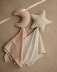 The mushie Star Lovey Blanket set includes two organic cotton comforters—one with a pink crescent moon and one with a white star—each with a matching cloth, perfect for soothing your little one.