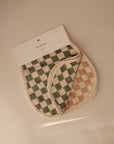 Two checkered muslin burp cloths—one green and white, one beige and white—overlap on a neutral background. The Organic Cotton Muslin Burp Cloth 2-Pack by mushie is shown together.