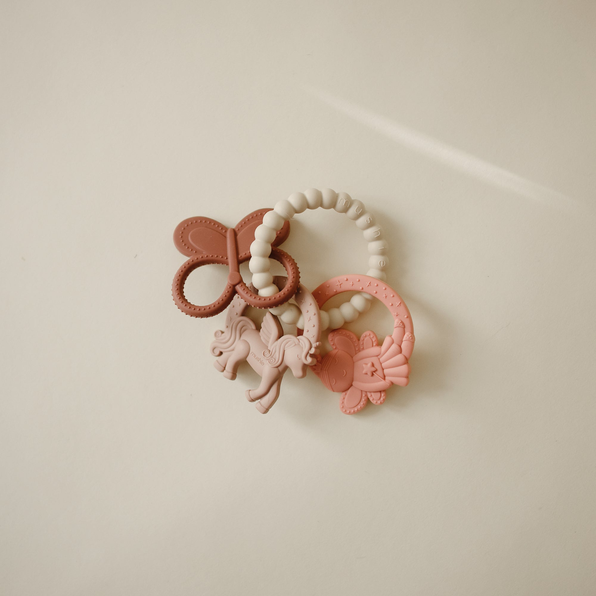 Three pastel mushie Fairy Teething Rings—food-grade silicone for sensory exploration.