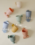 Mushie Pour and Play Bath Set: 7 colorful, ribbed cups for sensory fun in the bath.