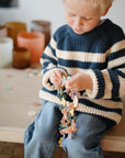 Young child plays with mushie HEX Connect Building Toy Set at a table.