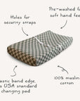 The mushie Extra Soft Muslin Changing Pad Cover features a gray and white checkered design, pre-washed for softness, with security strap holes and an elastic edge. Fits USA standard pads for a secure, comfortable fit.