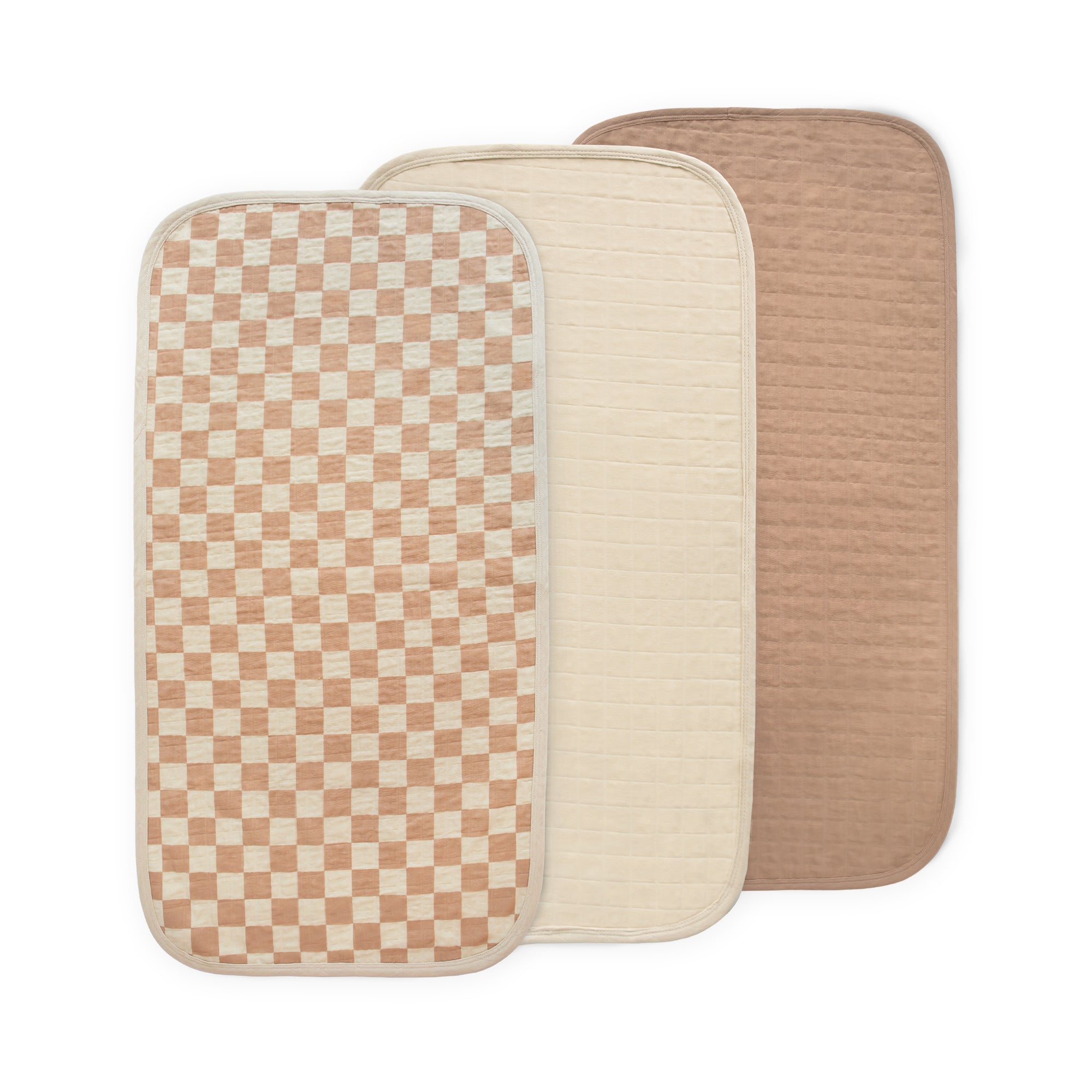 Three overlapping Mushie Changing Pad Liners in Check Combo color.