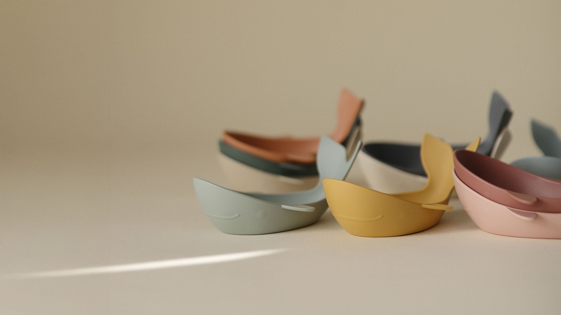 Whale bath stackers spread out on a clean beige surface, showing each nesting piece.