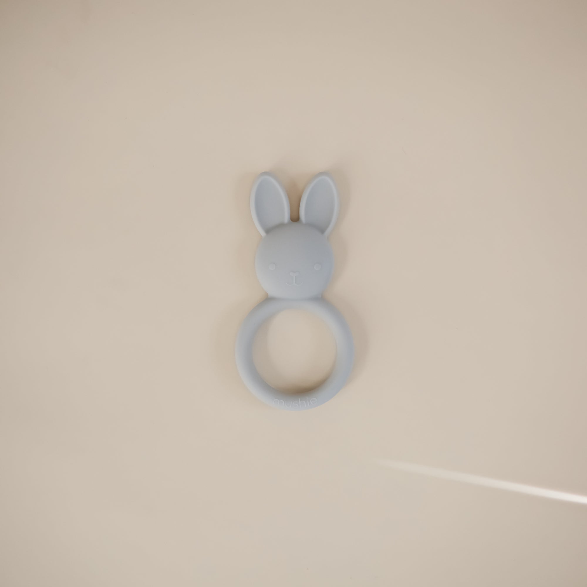 The mushie Bunny Teether is a gray silicone baby teether shown on a plain beige background.