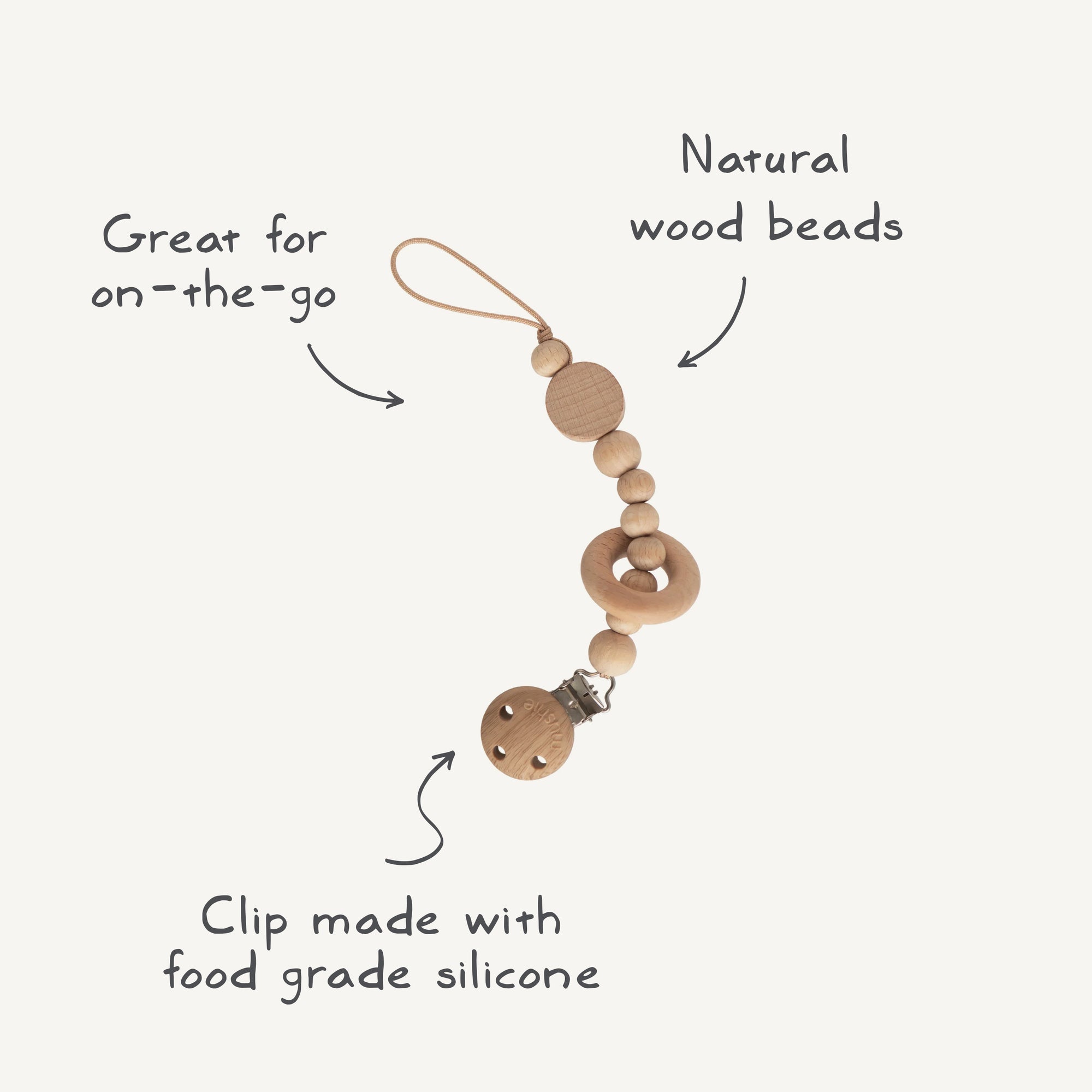 The mushie Silicone Pacifier Clip | Mila features natural wood beads, a circular wooden ring, and a food-grade silicone clip with looped string—combining safety and style for your little one’s on-the-go needs.
