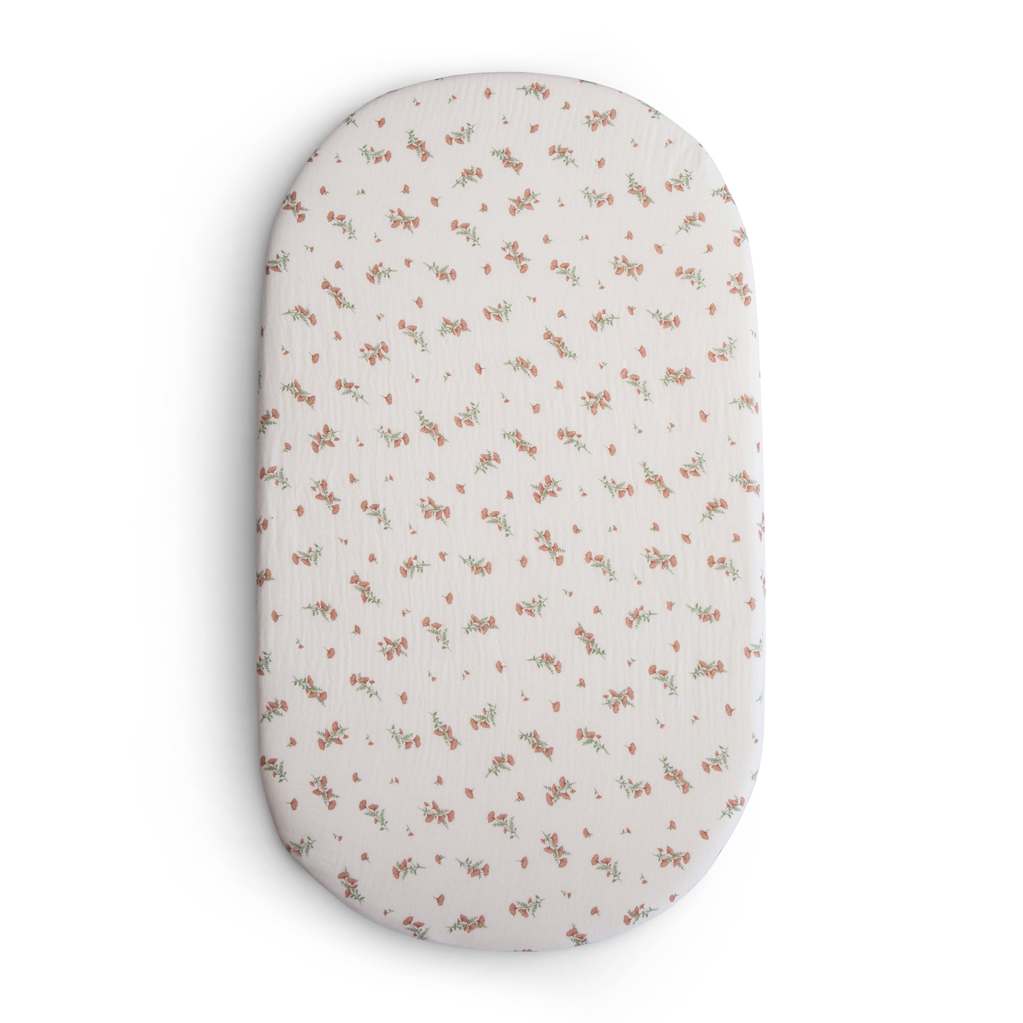 Mushie Extra Soft Bassinet Muslin Crib Sheet in white and pink floral pattern.