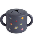 Mushie Snack Cup: spill-proof silicone, two handles, planet design—perfect for toddlers.