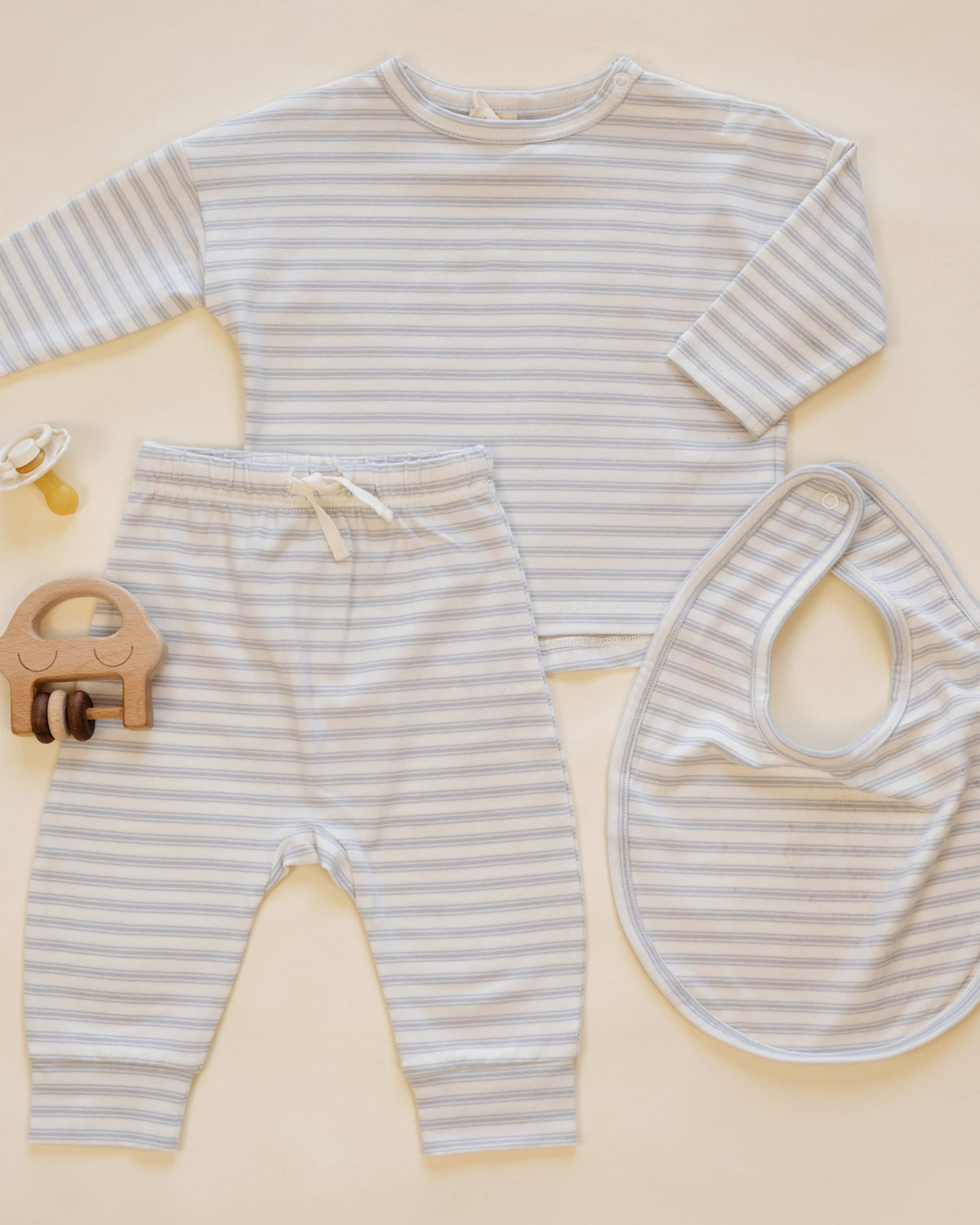 Rylee + Cru Long Sleeve Tee Cloud Stripe with bib, pacifier &amp; wooden elephant toy on cream.