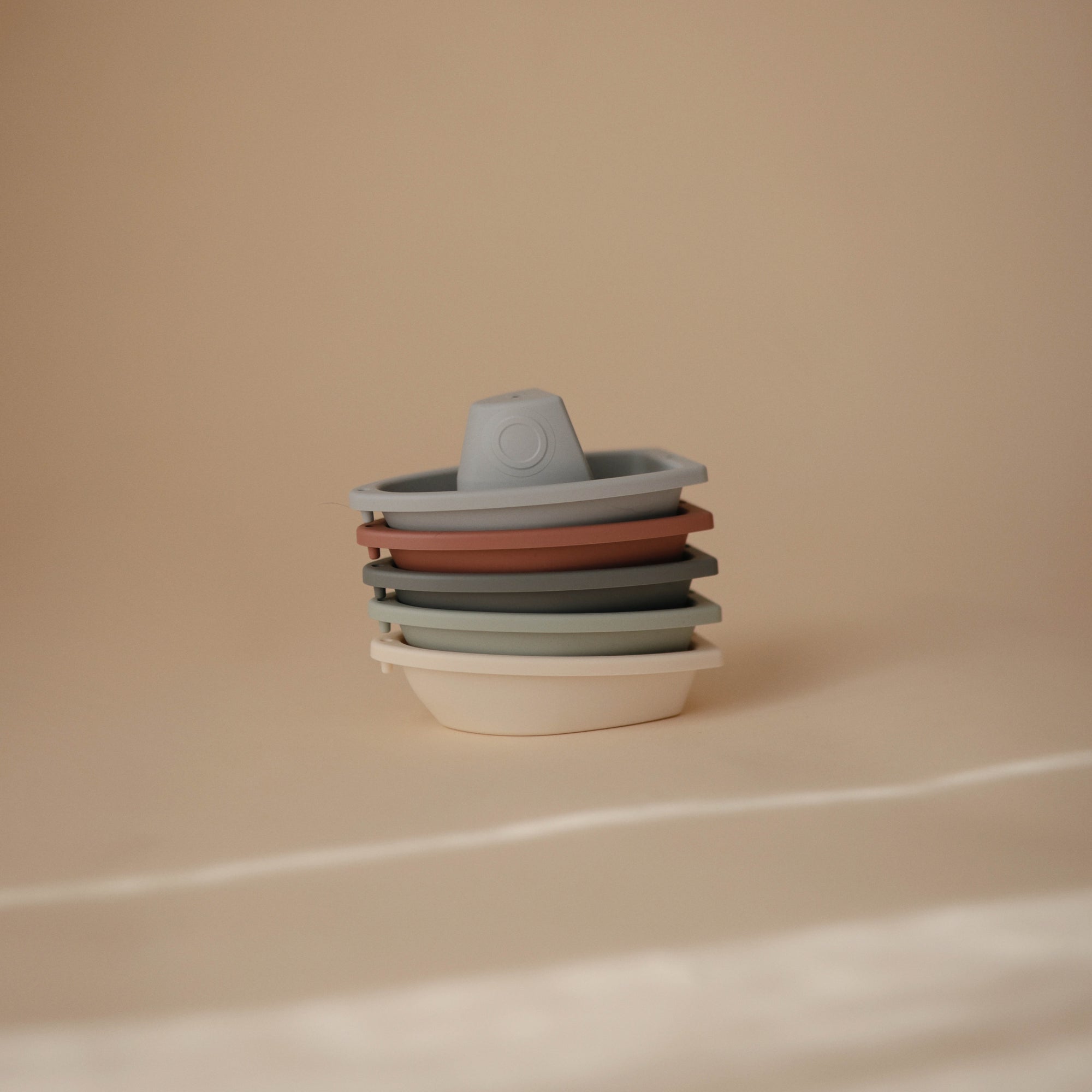 Mushie Bath Boats in neutral colors, perfect water play toys on a beige background.