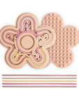 Mushie Silicone Sensory Toy in Petal: 2 mats and 6 sticks for fine motor play on white background.