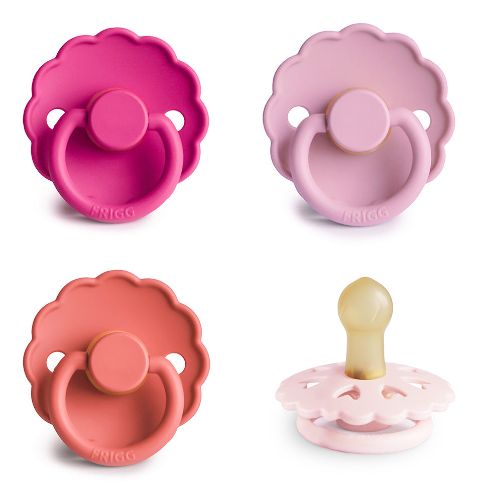 Four pink FRIGG Natural Rubber Pacifier 4-Pack units with scalloped shields and round handles.