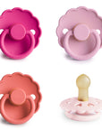 Four pink FRIGG Natural Rubber Pacifier 4-Pack units with scalloped shields and round handles.