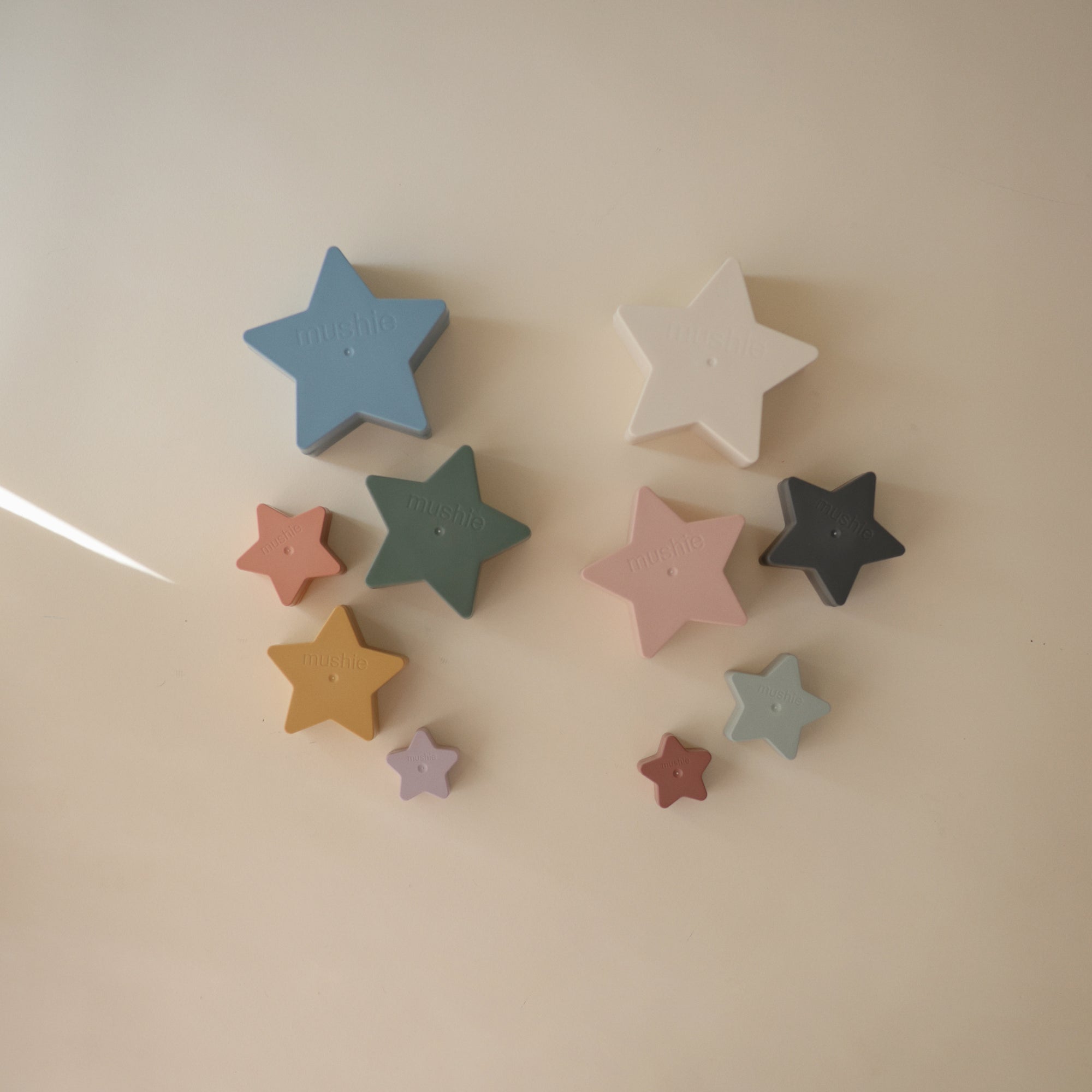 Mushie Nesting Stars Toy arranged on a light surface, perfect for fine motor skill play.