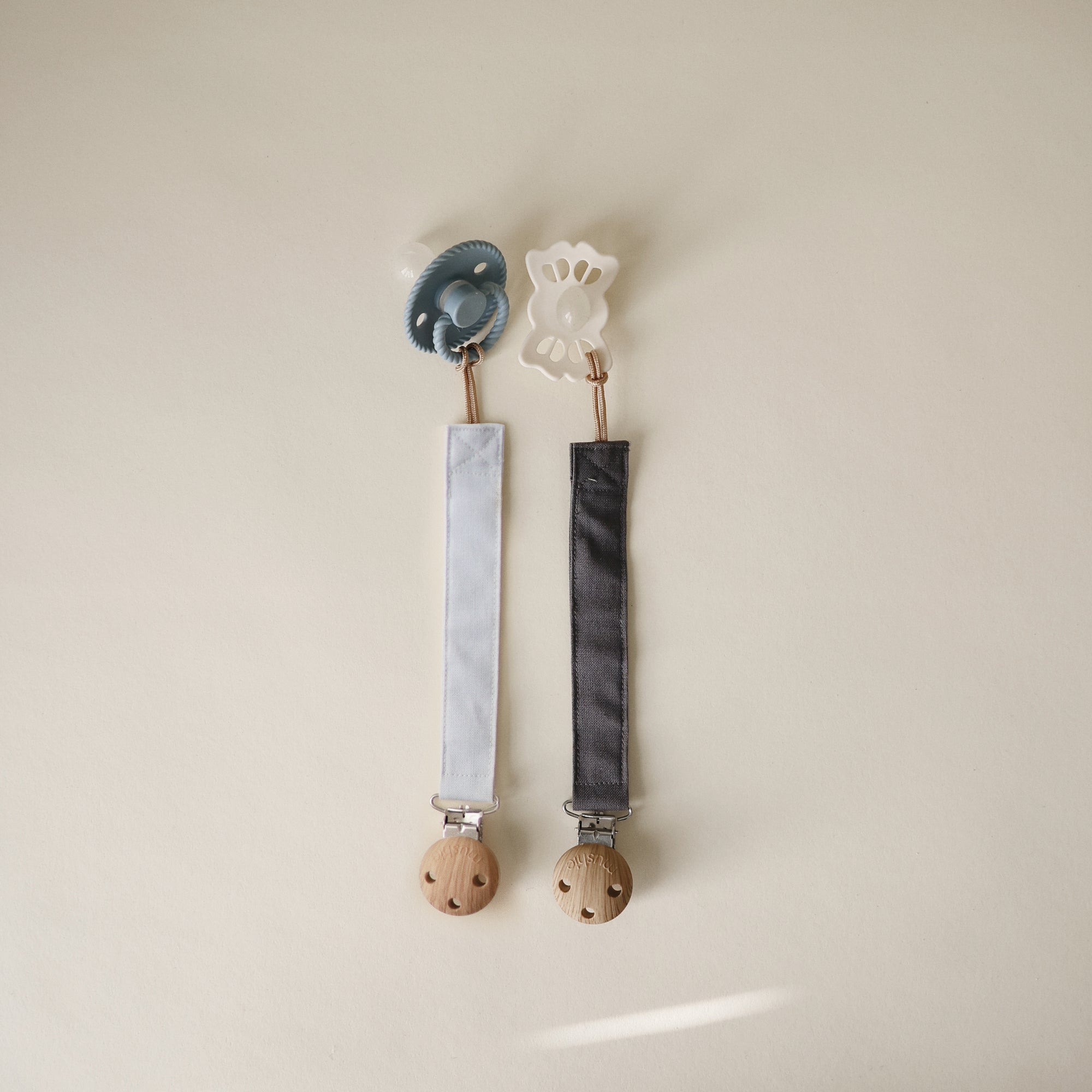 Mushie Linen Pacifier Clip 2-Pack: blue and white clips with fabric straps and wooden clasps.