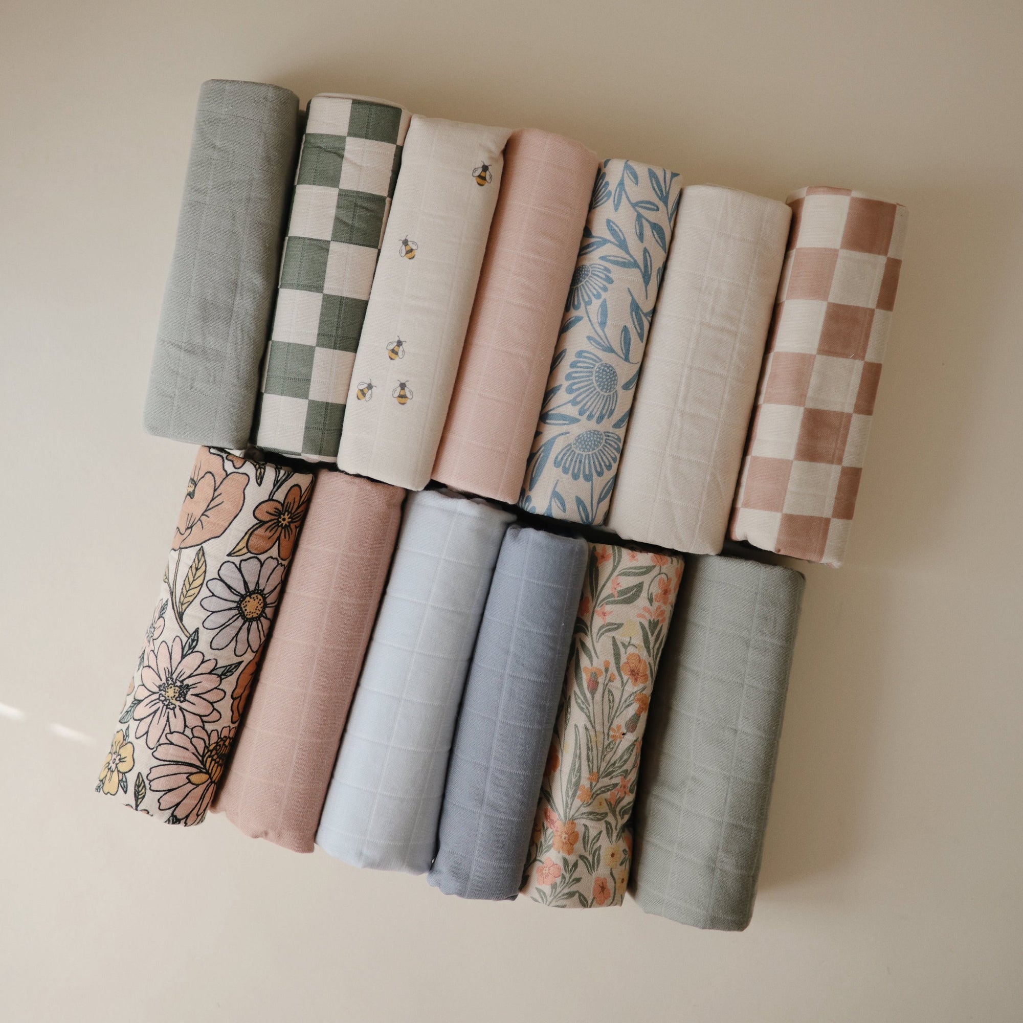 Mushie Changing Pad Liners: 12 organic cotton pieces in pastel floral or checkered patterns.