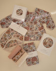 Mushie Changing Pad Liners and accessories arranged on a beige surface.