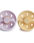 FRIGG Moon Natural Rubber Pacifier 2-Pack in lavender and beige, with cutouts and a knob.