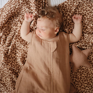 Lifestyle picture of a Mushie Sleep Bag in Natural on a baby.