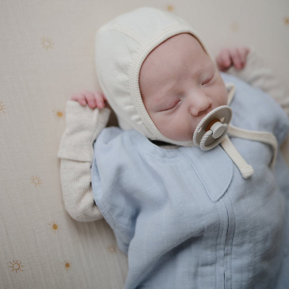 Lifestyle picture of a Mushie Sleep Bag in Baby Blue on a baby.